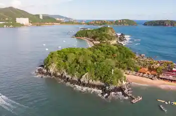 Vista aérea de Isla Ixtapa rodeada por el mar Pacífico, sus matorrales verdes y la zona de playa.