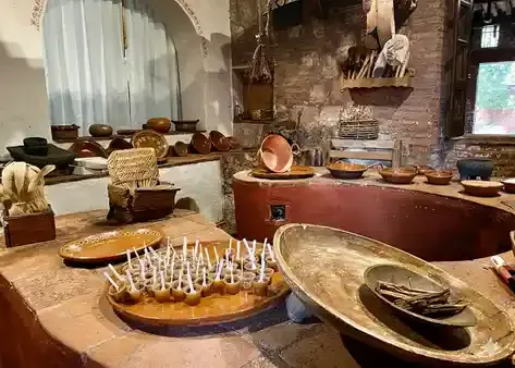Cocina tradicional michoacana con cazuelas de cobre y muestras de dulces típicos sobre una mesa.