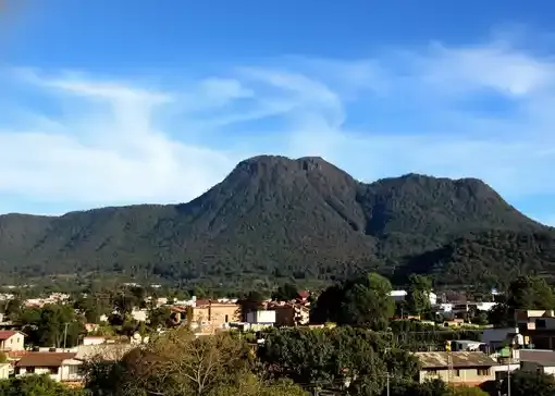 Panorámica del Cerro del Cacique cubierto de vegetación sobre la zona urbana de Zitácuaro.