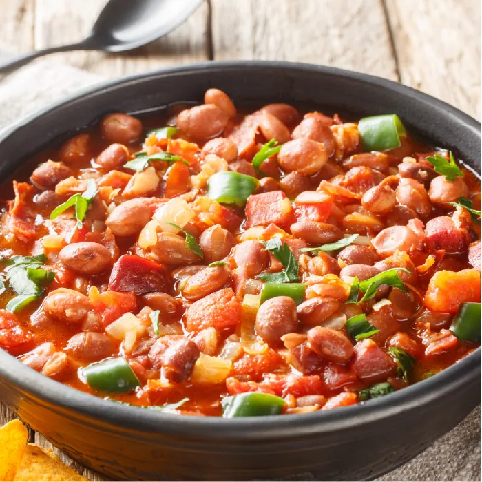 Cazuela de frijoles charros preparados con tocino, chiles verdes, jitomate y cilantro.