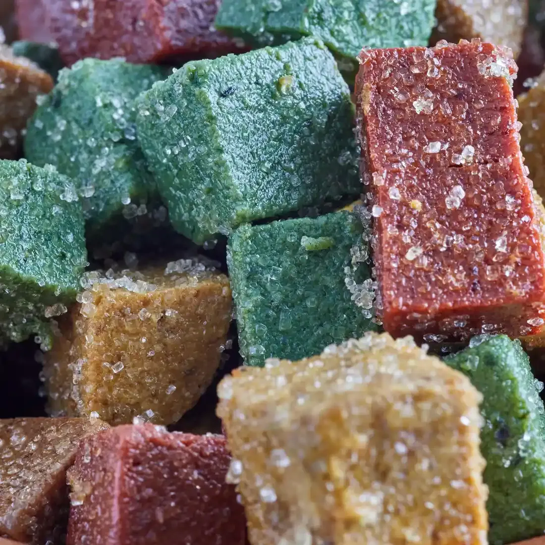 Cubos de ate tradicional michoacano de varios colores espolvoreados con azúcar refinada.